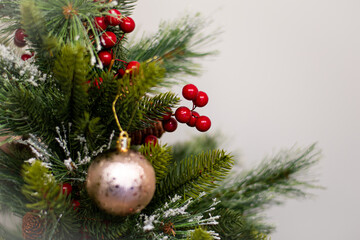 árbol de navidad decorado con bolas brillantes y muerdago sobre un fondo blanco claro