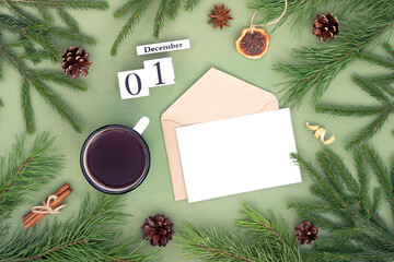December 1. Calendar date, white blank with craft envelope, cup of tea and natural decor on green background. Hello winter. Template for your design, greeting card