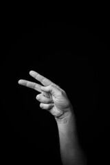 Hand demonstrating the French sign language letter 'K' with copy space