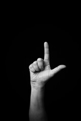 Hand demonstrating the French sign language letter 'L' with copy space