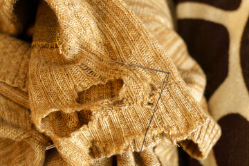 Mending clothes. Repairing woolen sweaters, shopping less concept. Selective focus