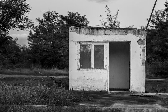 Grayscale shot of an old abandoned kusk in a rural field