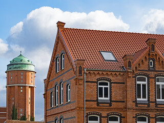 Fototapeta na wymiar Alter Wasserturm und historisches Backsteingebäude in der Stadt Nienburg an der Weser, Niedersachsen, Deutschland