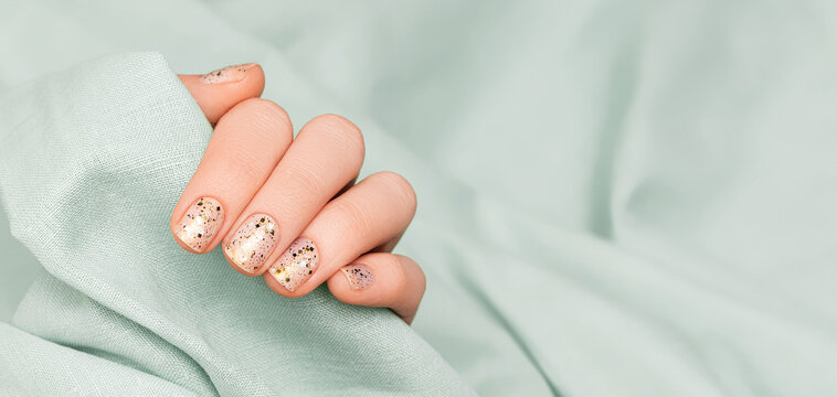 Advertisng banner with glitter pink nail polish manicure and green nail art on background.