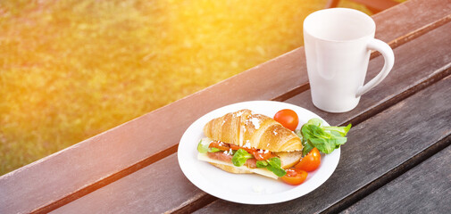 Advertisng banner with fresh croissant with ham and cheese on background. Tasty croissant and...