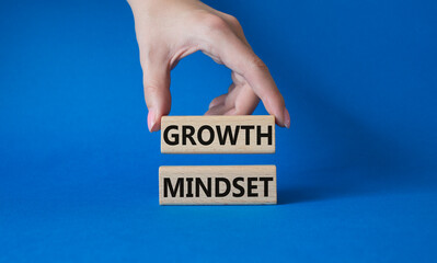Growth Mindset symbol. Concept word Growth Mindset on wooden blocks. Businessman hand. Beautiful blue background. Business and Growth Mindset concept. Copy space