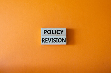 Policy revision symbol. Concept word Policy revision on wooden blocks. Beautiful orange background. Business and Policy revision concept. Copy space