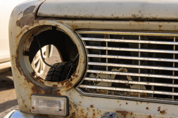 Close-up of an old rusty semi-disassembled vintage car from the USSR abandoned on the street