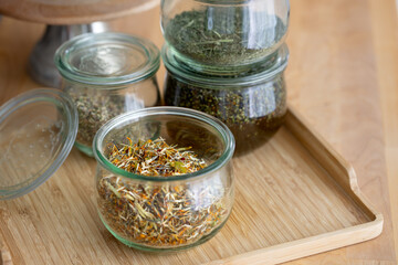 Homemade ingredients for massage oil in glass jars on wooden background lavender and flower oil