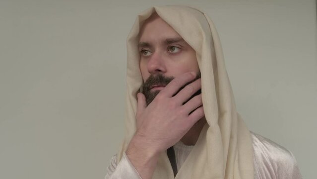 biblical scene, Jesus Christ, young pensive bearded man, guy 30 years in white light vestment, beige cape stands in image of Savior, concept of Holy Scriptures of Old and New Testaments