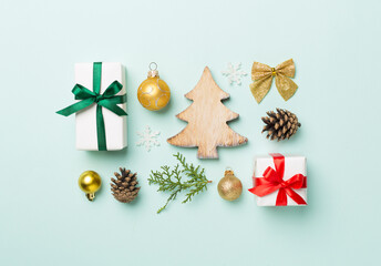 Flat lay with christmas gift boxes, toys, juniper and cones on color background