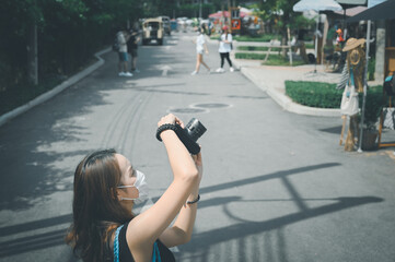 Young woman traveller using camera when her tour a street market