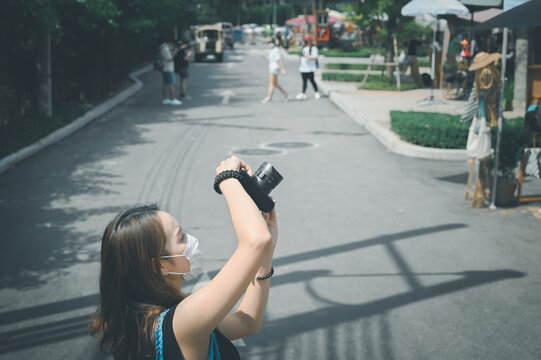Young woman traveller using camera when her tour a street market