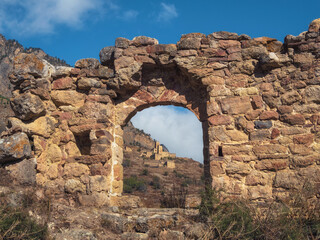 Old stone wall with arched passage. Old Egical towers complex, one of the largest medieval castle-type tower villages, located on the extremity of the mountain range in Ingushetia, Russia.