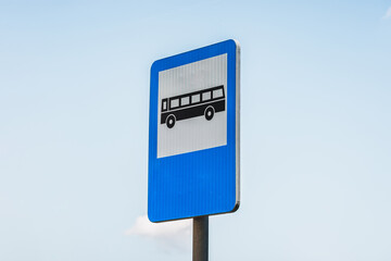 Close-up to a blue and white rectangular bus stop sign against clear sky - 548009930