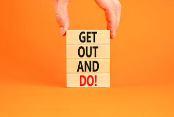 Motivational get out and do symbol. Concept words Get out and do on wooden cubes. Beautiful orange table orange background. Businessman hand. Business motivational get out and do concept. Copy space.