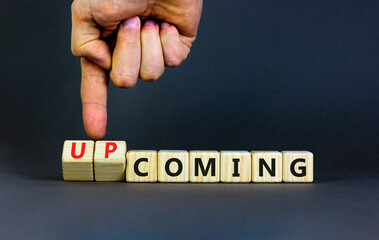 Coming or upcoming symbol. Concept words Coming and Upcoming on wooden cubes. Businessman hand. Beautiful grey table grey background. Business coming or upcoming concept. Copy space.