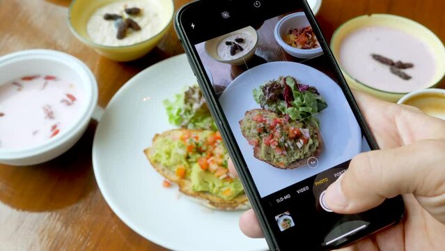 Male person take photos of healthy breakfast food by modern smartphone