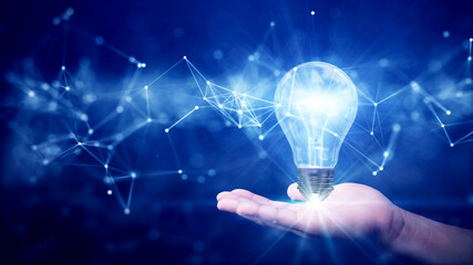business idea creative concept technology. Illuminated light bulb and connected polygons above hand on dark blue background.