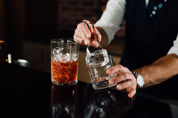 Close up shot of a bartender putting ice and preparing a cocktail