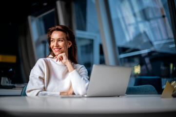 Middle aged business woman using laptop while sitting at desk at the office. Executive...