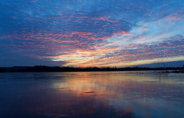 Sunset over the lake. Winter landscape.