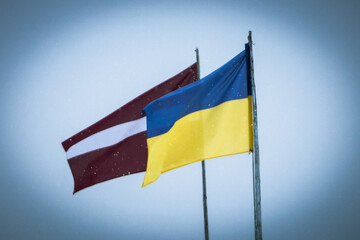 Ukrainian and Latvian flags in  winter
