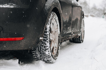 Winter tire. Car on snow road. Tires on snowy highway detail.