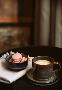  Cup of coffee and  sweet French macarons  on a round coffee table.