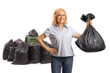 Smiling mature woman throwing a plastic waste bag