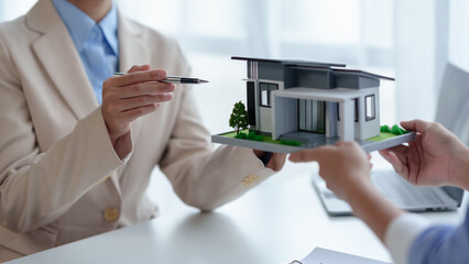 Real estate agents sell houses and land to customer by offering a model house as an example...