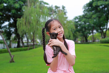 Asian girl show her kitten in the garden