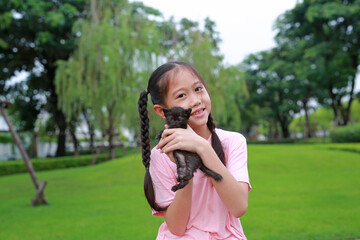 Fototapeta premium Asian girl show her kitten in the garden