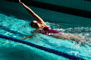 Young woman swimmer training in the pool. Professional swimmer inside the pool.
