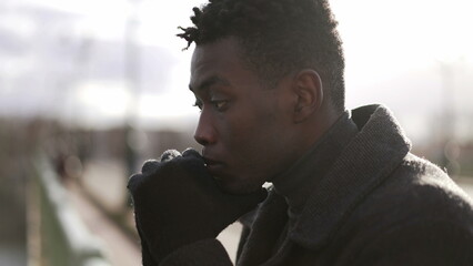 Pensive black African man standing by bridge thinking about life looking at horizon2