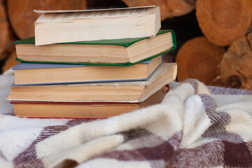 a close stack of old books on the woolen blanket  on wooden background in vintage style....