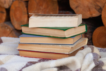 a close stack of old books on the woolen blanket  on wooden background in vintage style....