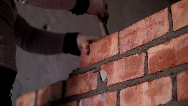 worker lays out a brick wall