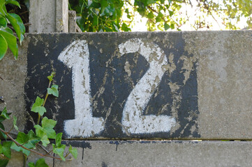 Hand Painted Number '12' on Old Grey Concrete Wall 
