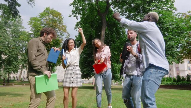 group of student friends walking through the park. slow motion.