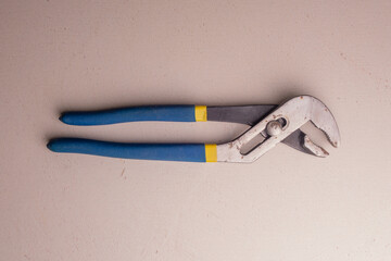 Adjustable plumbing wrench with blue handles. Joiner's hand tool.
