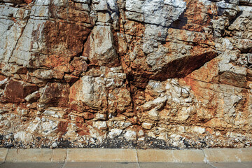 Grungy cragged bumpy pitted cavity stone facade, split layer gap.Ruined cracked shattered worn rough hiking canyon.Old ragged grunge steep marble cliff. Grand vintage crannied damaged impressive gorge
