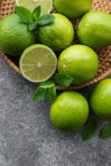 Green  Limes with fresh mint leaves on wicker tray