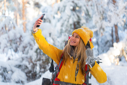Photo of a blond caucasian woman during outdoor hiking in winter forest.