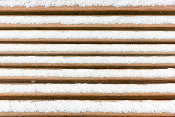 Winter background of a snowy park bench