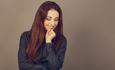 Beautiful confident happy thinking smiling business woman looking down with hand under the face in...