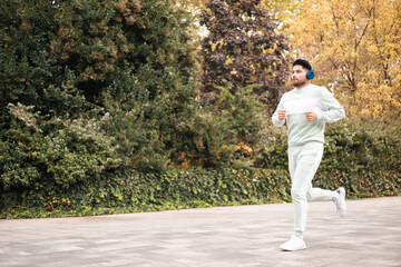 Fototapeta premium young colombian man running in park of a city, copyspace