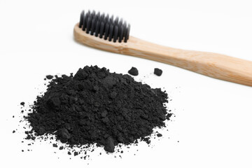Concept of deep and detailed cleaning of the teeth. Black charcoal disclosing powder for bleaching. Dental whitening concept. Biodegradable toothbrush with soft bristle.