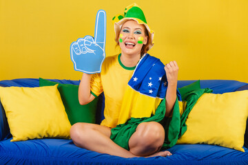 Caucasian, redhead, Brazilian, Brazilian soccer fan on couch with foam finger partying