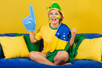 Caucasian, redhead, Brazilian, Brazilian soccer fan on couch with foam finger partying